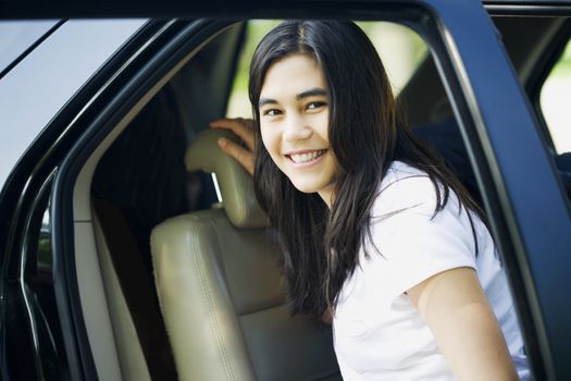 Beautiful teen girl standing by her car door