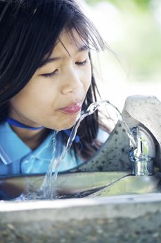 Girl drinking from water fountain