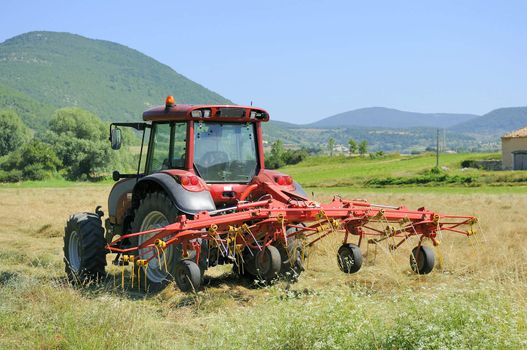 Small scale farming with tractor and plow in field