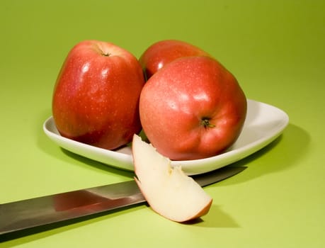 Juicy red apples on green background