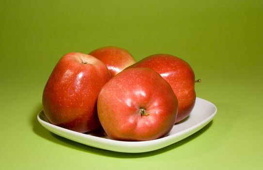 Juicy red apples on green background