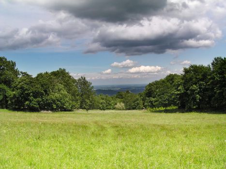 Green landscape under heavy clouds