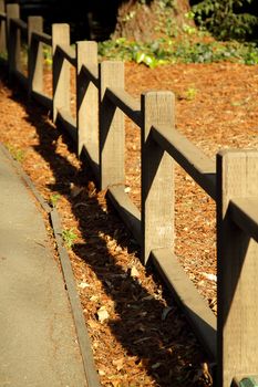 Wooden fence by the trail on sunny day