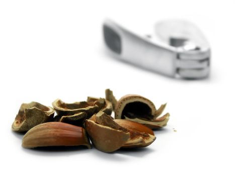 Hazel nut shells and cracker on white background