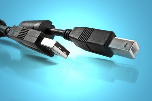 Close up of two usb cables against blue light effect background