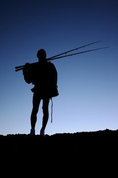 Silhouette of a fisherman or angler with his fishing rods