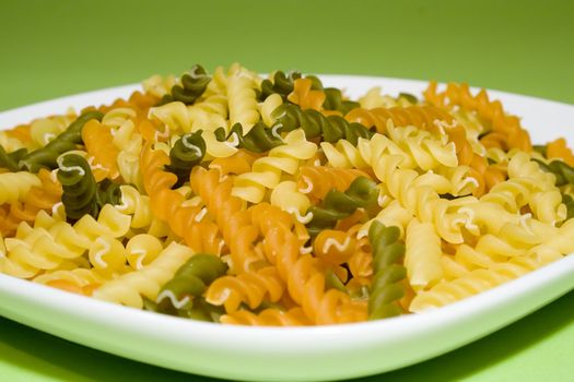 Pasta on green background (on white plate)