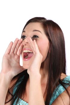 Pretty brunette woman with hands cupped to mouth and shouting