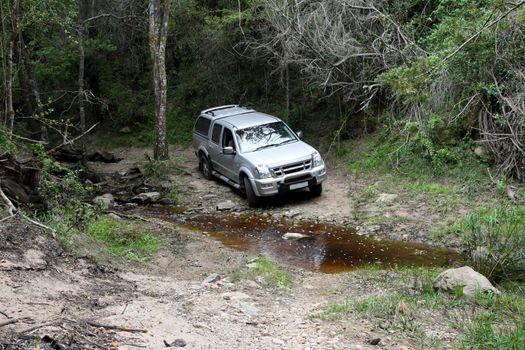 Offroad 4x4 vehicle at a stream in the wilderness