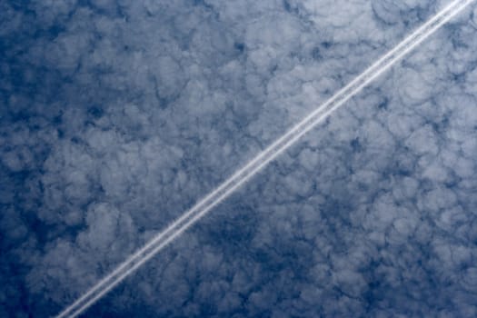 Shot of the trail behind the plane - condensed steam in the sky
