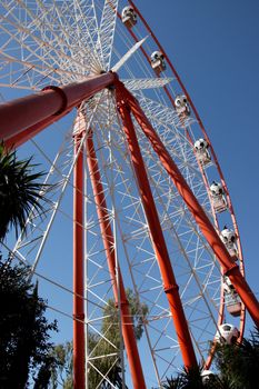 Ferris wheel against blue sky viewed from the ground