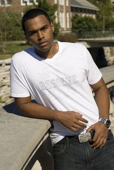 Attractive young African American male playing posing in a white t-shirt and jeans.