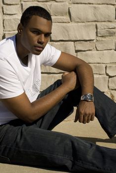 Attractive young African American male playing posing in a white t-shirt and jeans.