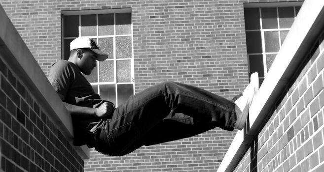 Attractive young African American male playing posing in a t-shirt, jeans, baseball cap.