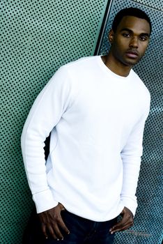 Attractive young African American male playing posing in a white t-shirt and jeans.