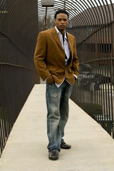 Attractive young man in a suit and jeans on a bridge.
