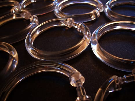 Several shower curtain rings on a dark surface.