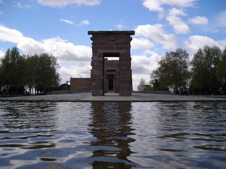 View of the Debod Temple in Madrid surrounded by a pond and trees, a gift from egiptian king to Juan Carlos I, King of Spain.