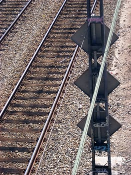 View of train rails with some railway signals and wooden sleepers.