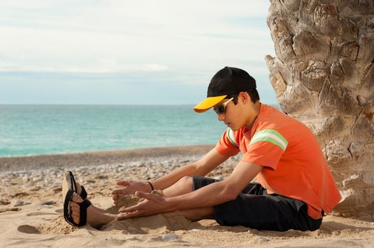 Teenager enjoying himself on a sandy beach