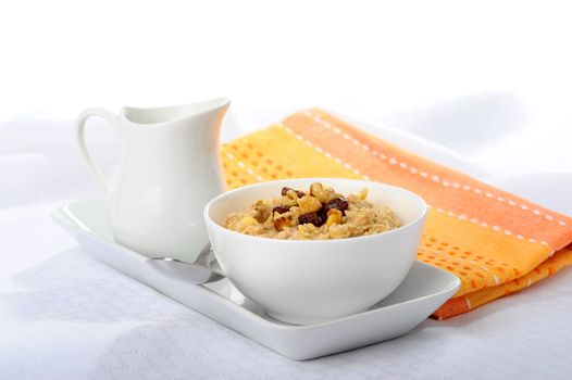 Bowl of hot oatmeal with raisins and walnuts.