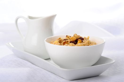 Bowl of delicious oatmeal with raisins and chopped walnuts.