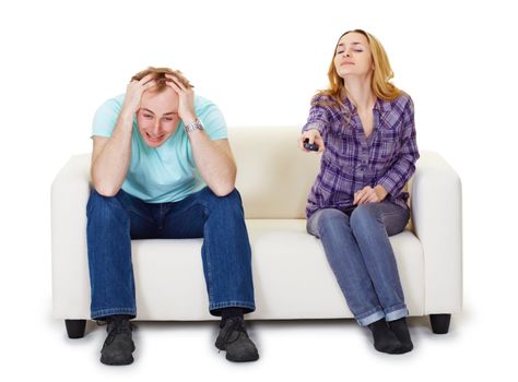Nervous husband and wife sitting on the couch watching TV isolated on white background