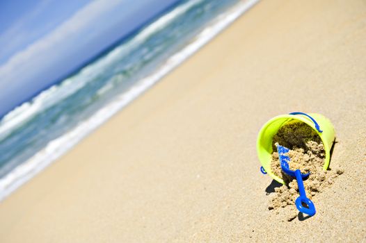 Toy bucket and shovel on an empty beach