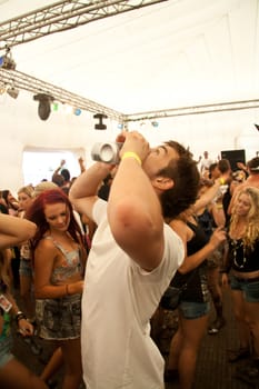 Guy drinking two beers at the same time in the POD stage at the Future Musical Festival 2011 in Brisbane Australia.