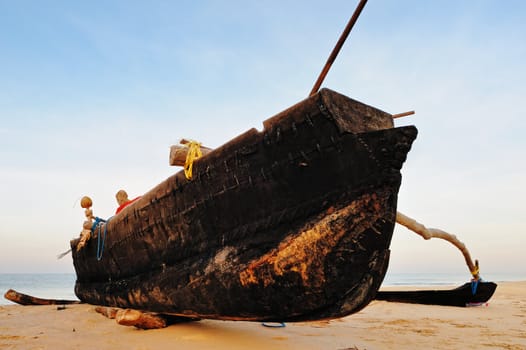 Old wooden fishing boat on the sandy shore