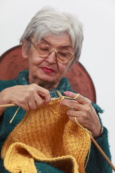 Image of an old woman knitting.Selective focus on the hands.