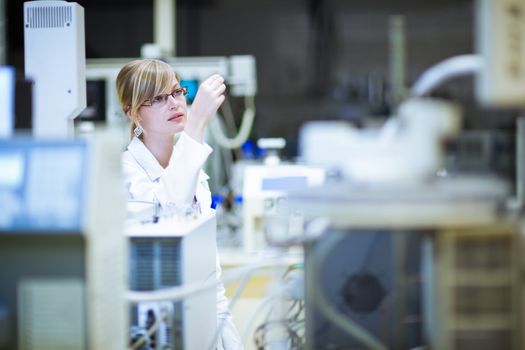 portrait of a female researcher carrying out research in a chemistry lab (color toned image; shallow DOF)