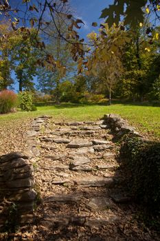 Rough stone steps with ivy leading to a lawn and garden