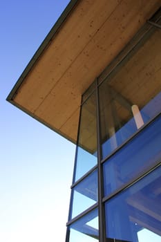 the modern glass facade with wooden ceiling