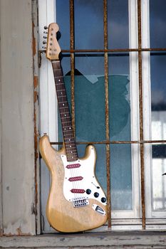 the old wooden guitar in the window