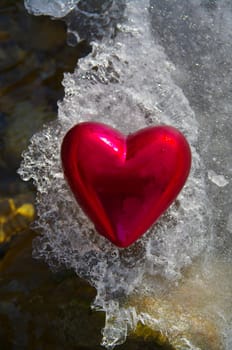 a red  heart on a real snowy icy surface