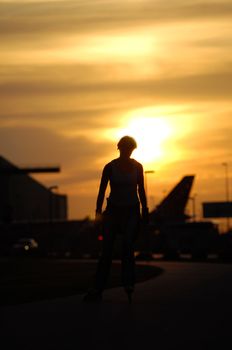 Silhouette of a activ woman is running on roller blades