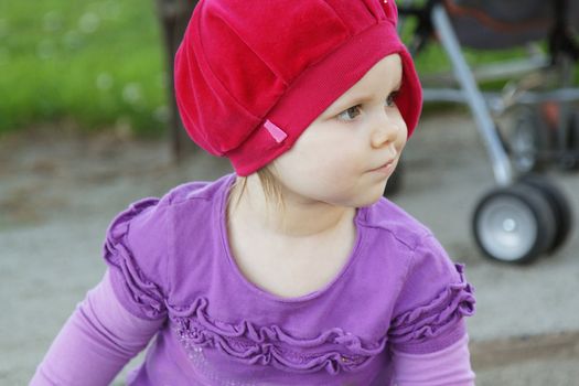 Cute toddler girl with red beret on playground