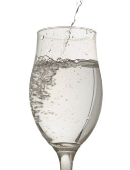 A glass with water pouring from above