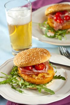 Delicious chicken burger with tomatoes on a sesame bun
