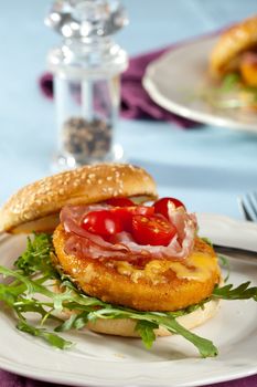 Freshly made chickenburger with tomatoes, bacon and cheese