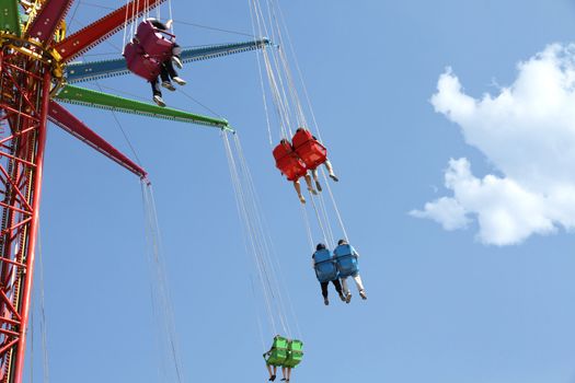 Colored carousel in an amusement park against blue sky