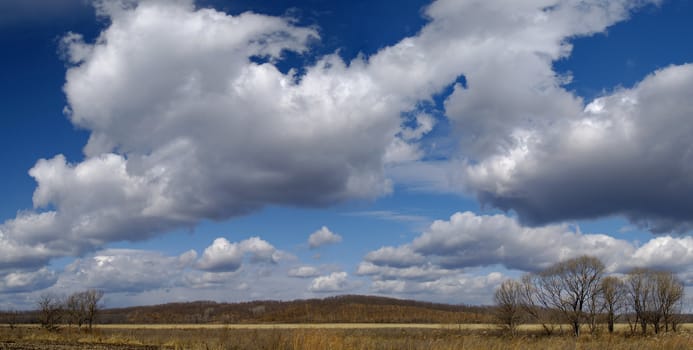 An autumn landscape with a meadow and clouds