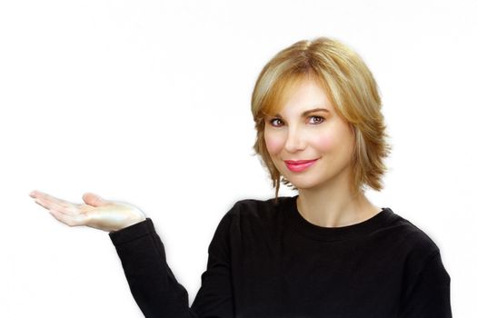 Close-up of a lovely young sandy-blonde woman with her right hand extended, palm up, plain white background.