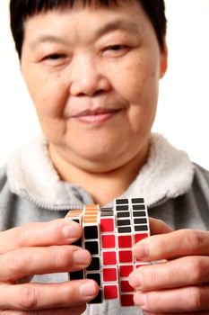senior chinese woman playing  rubik cube