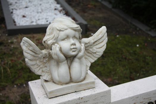 white concrete Guardian Angel grave ornament on a graveyard