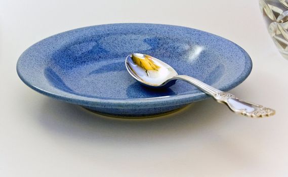 tablespoon in blue plate on a white background