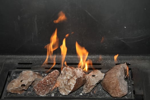 A fireplace with burning flames and fake stones