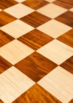 Wooden chess board with brown and yellow squares background . Natural wood