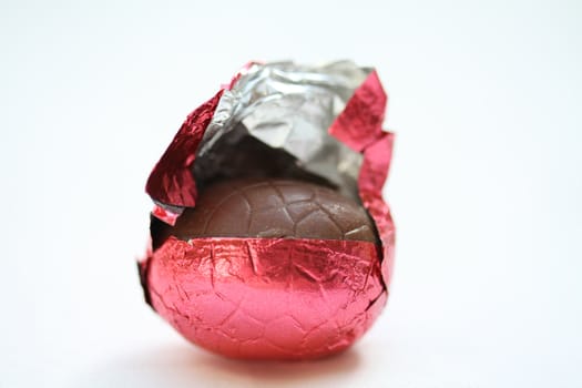 A chocolate easter egg in red wrapping, close up